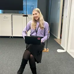 Emilia toimiston keinussa läppäri sylissä