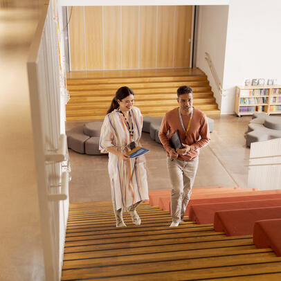 Opettajat kävelevät koulun rappusissa.