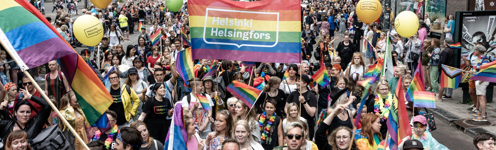 Ihmisiä kävelemässä Pride-kulkueessa