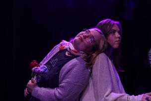 Kaksi henkilöä nojaavat toisiinsa selät vastakkain