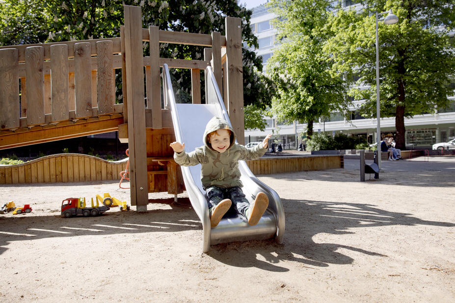 Lapsi laskee liukumäkeä leikkipuistossa.