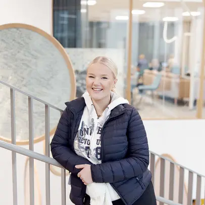 lukiolaistyttö seisoo koulun portaikossa