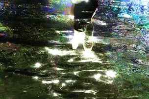 Abstrakti valokuva, jossa voi nähdä veden välkettä ja värejä
