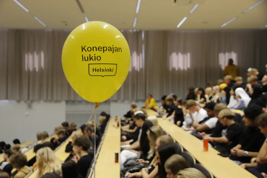 Konepajan lukion opiskelijat istuvat auditoriossa.
