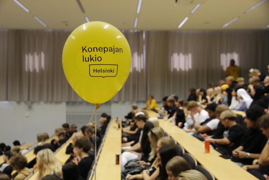 Konepajan lukion opiskelijat istuvat auditoriossa.