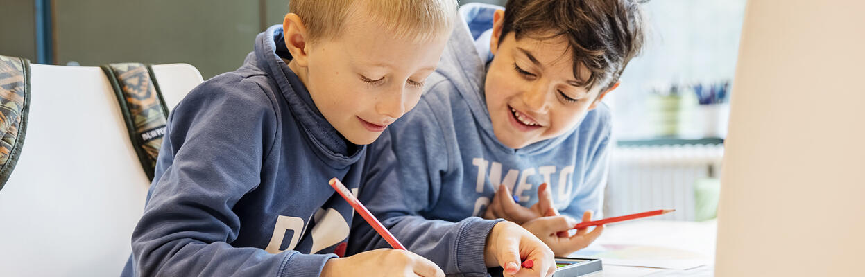 Lapset tekevät tehtäviä pöydän ääressä