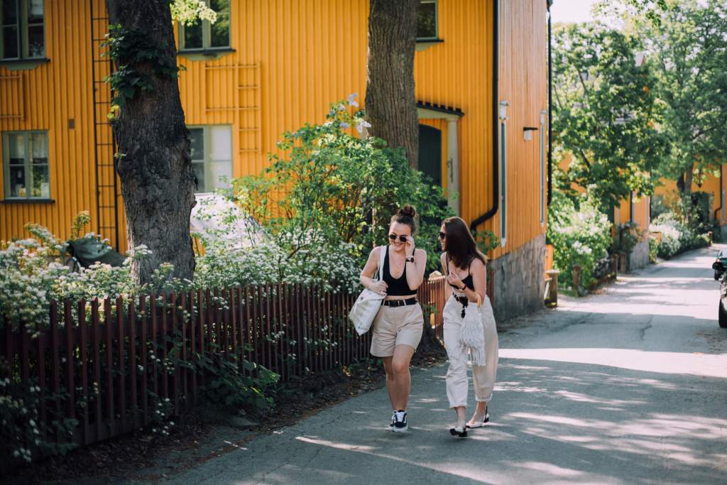 Ystävykset kävelevät kadulla Puu-Käpylässä kesällä.