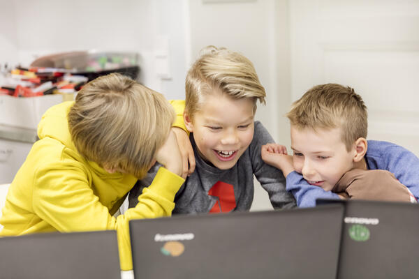 Oppilaat tekevät ryhmätyötä tietokoneella