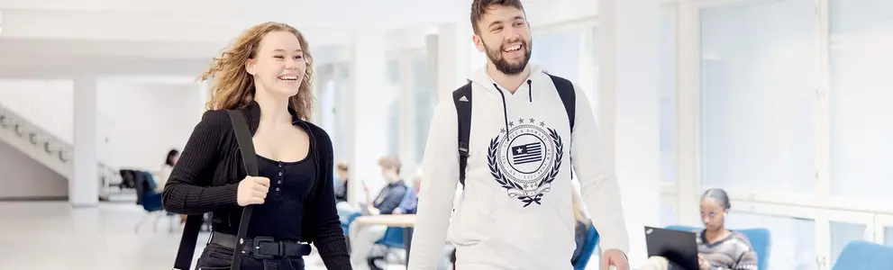 nuoria opiskelijoita kävelemässä oppilaitoksen käytävällä