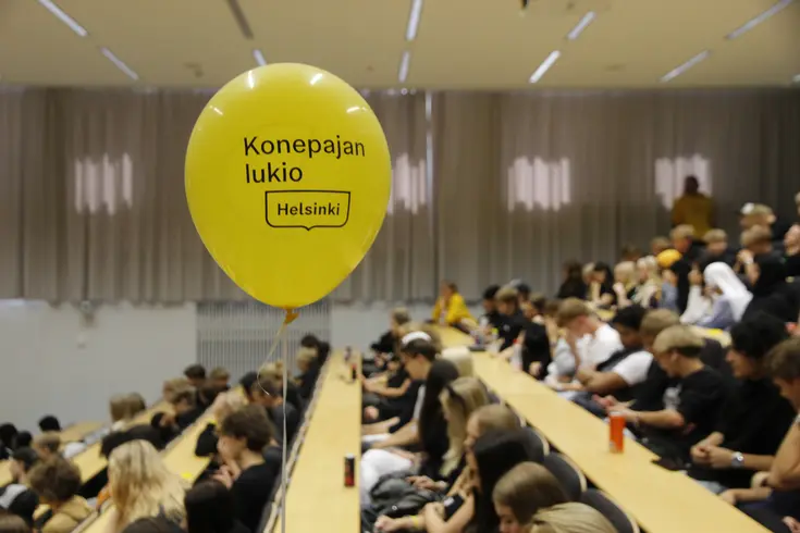 Konepajan lukion opiskelijat istuvat auditoriossa.