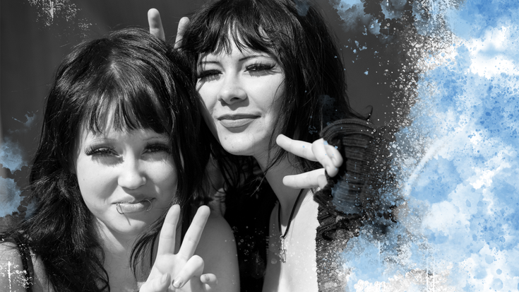 Kuvassa kaksi opiskelijaa halaa ja hymyilee kameralle. Kuvan oieka laita rajautuu kuvitusroiskeeseen.