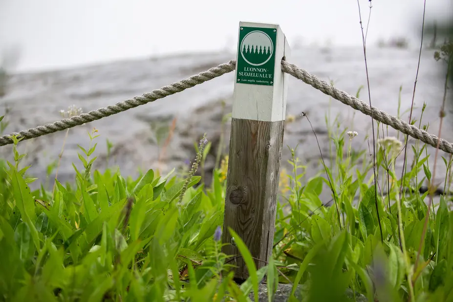 Luonnonsuojelualueen symboli puisen tolpan yläosassa