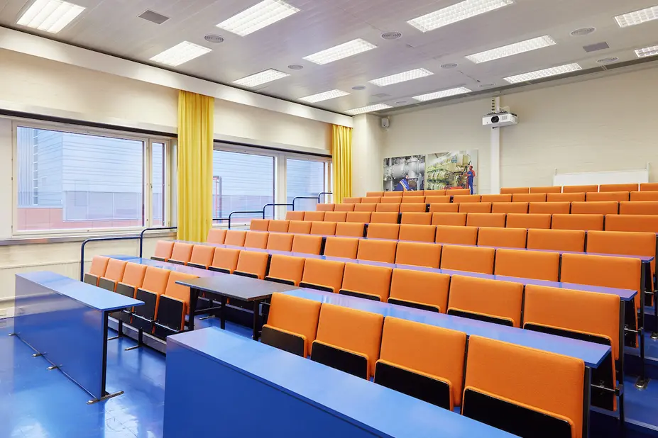 Auditorio, oranssit penkit ja sininen lattia.