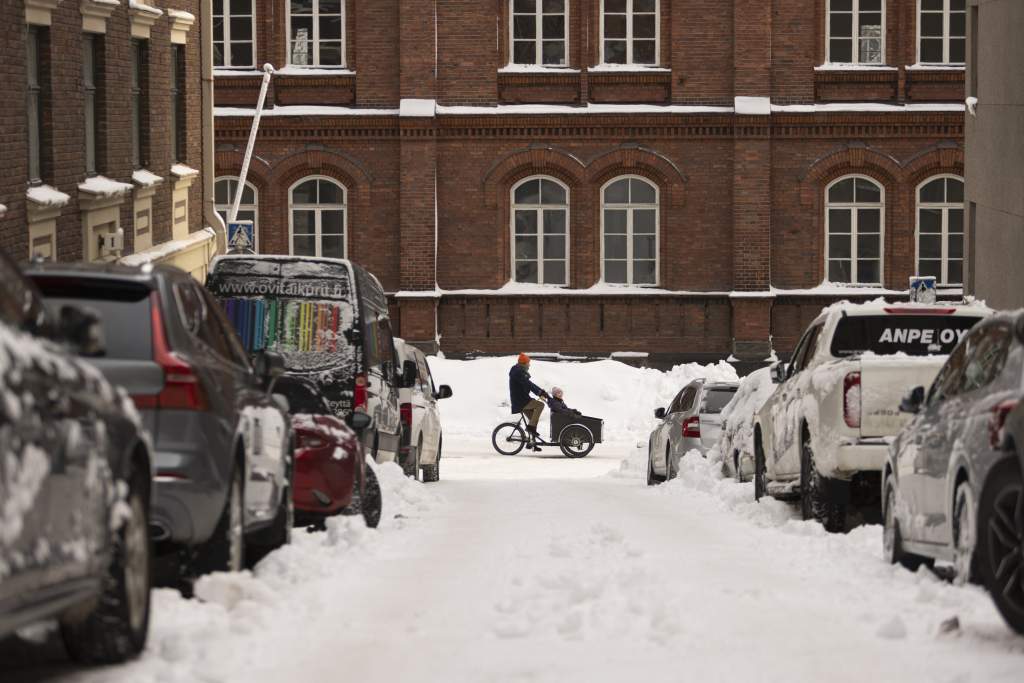 Pyöräilijä lumisella kadulla
