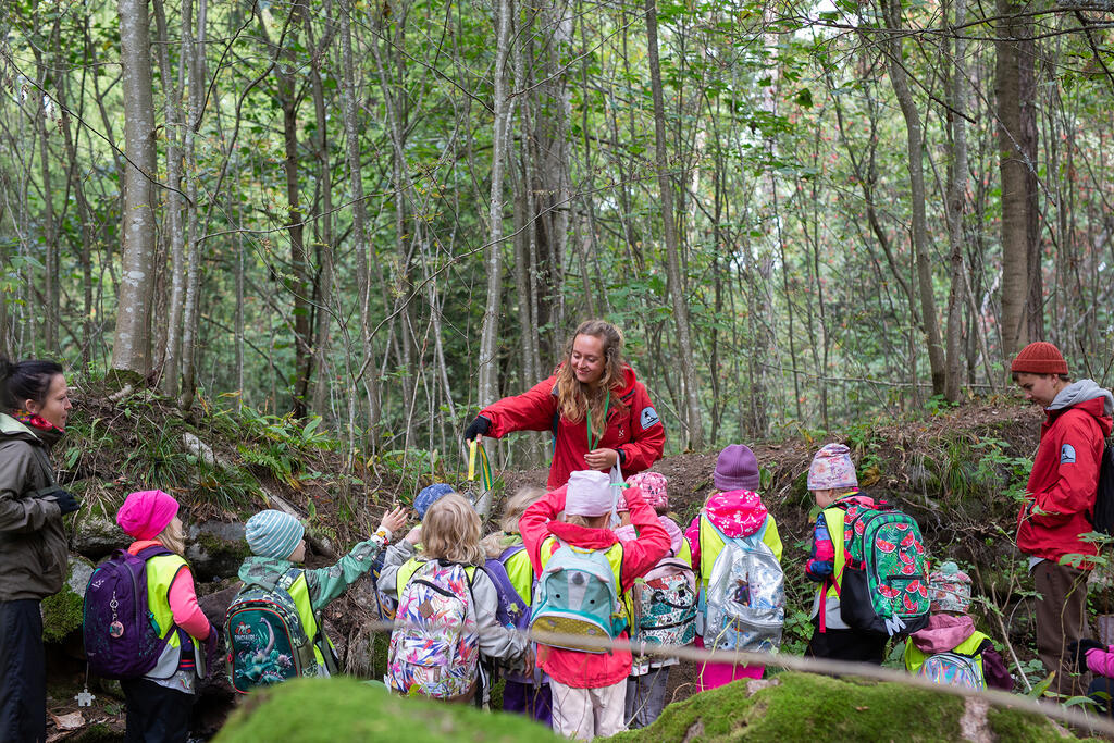 Ympäristökasvattaja jakaa lapsille luuppeja metsässä