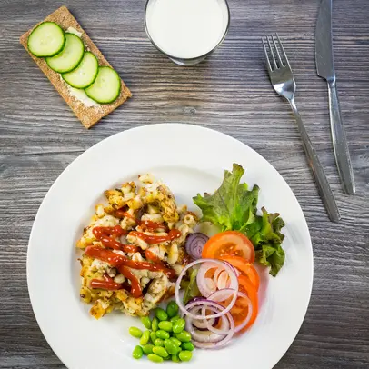 En modellportion för skolmåltider med makaronilåda och sallad samt en måltidsdryck och ett knäckebröd.