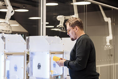 Mies käyttämässä 3D-tulostinta.