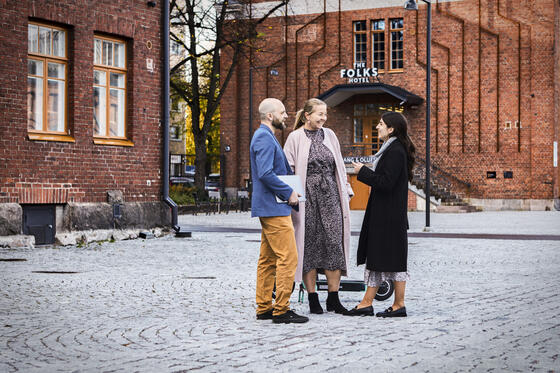 En man och två kvinnor pratar med varandra i Vallila området.