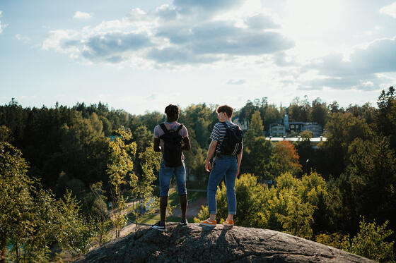 Två personer i naturen på en klippa.