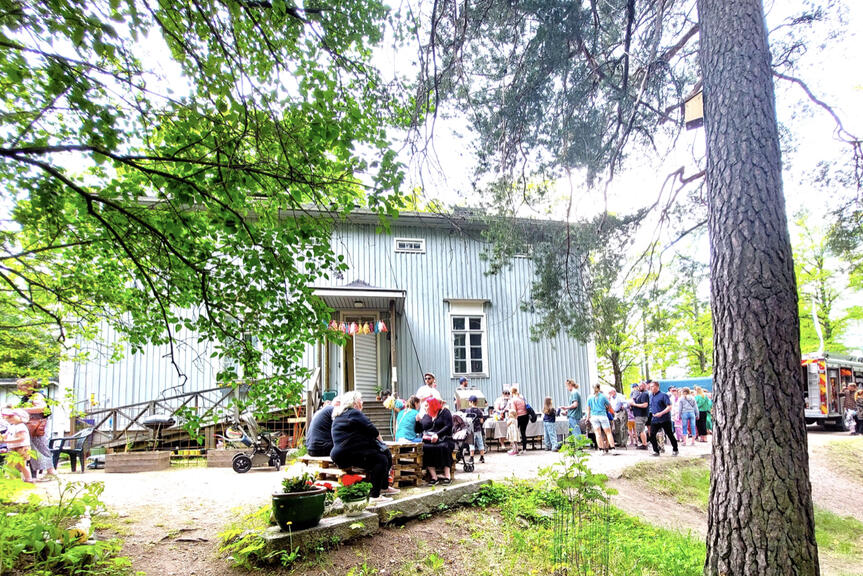 Ihmiset kokoontuneena Stadin yhteisötalon pihassa.