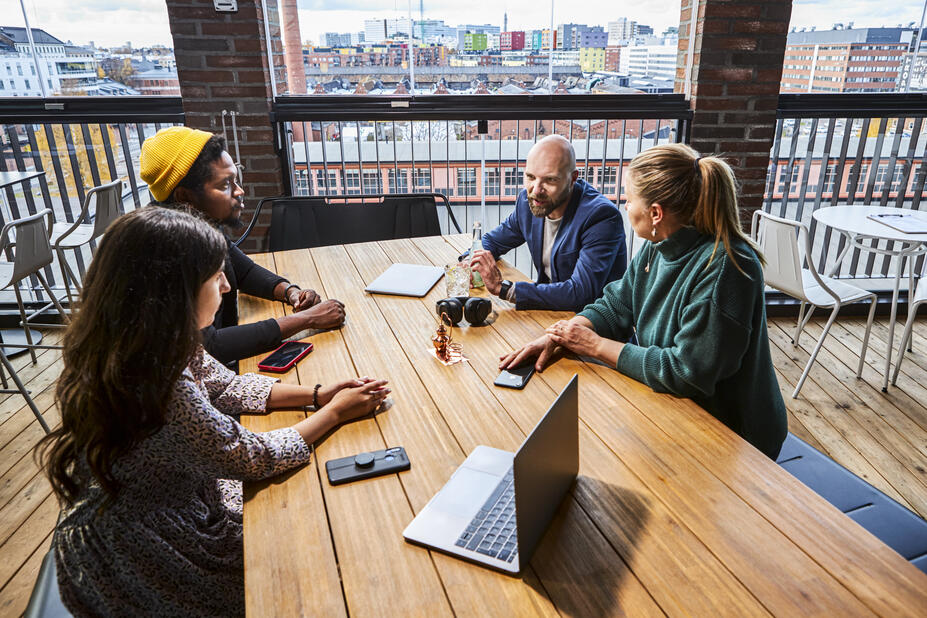 Four employees talking at the table.