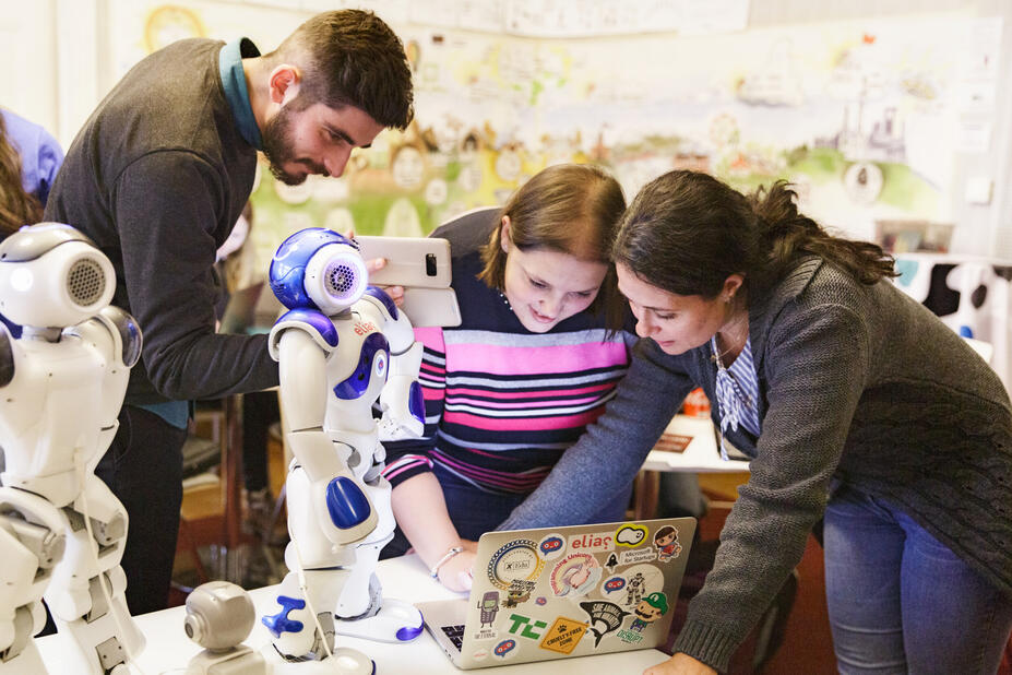 yksi mies ja kaksi naista tutkivat robottia