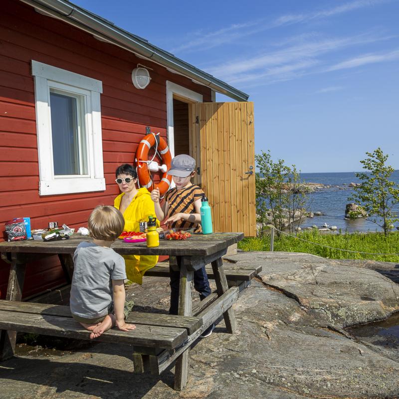 A woman and a child in fron of a sauna in Pihlajasaari island.