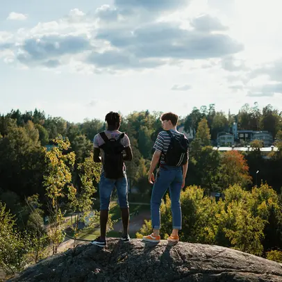 Two people on a cliff in sunny weather.