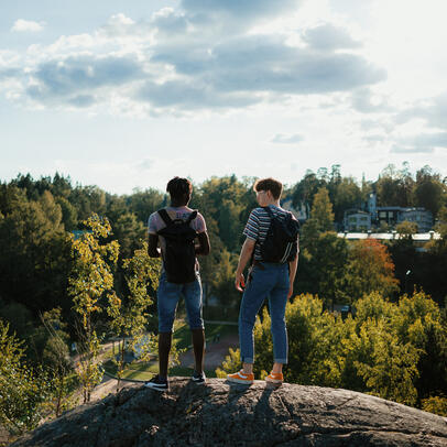 Två personer i naturen på en klippa.