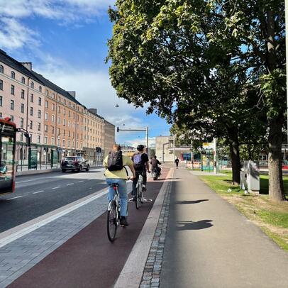 Pyöräilijöitä ja bussi katunäkymässä Helsingissä.