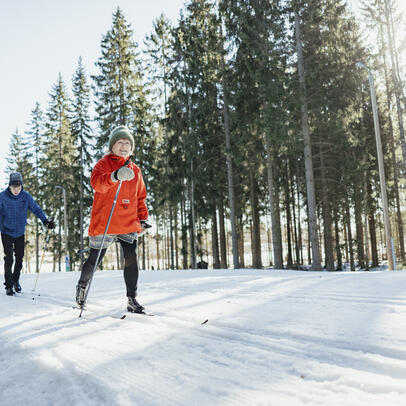 Kolme henkilöä hiihtämässä Paloheinässä.