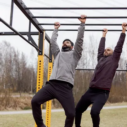 Två personer som tränar på ett utegym.