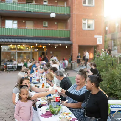 Smiling people dining outdoors in Malminkartano.