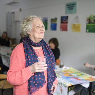 Elder woman smiles at the meeting for the senior citizens in Helsinki.