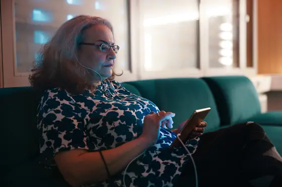 A woman scrolls through her phone with concentration.