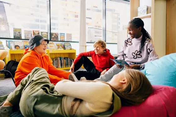 Unga som ler mot varandra i ett bibliotek.