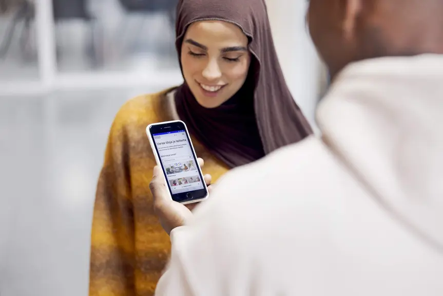 Two people making a reservation in Varaamo using a smartphone.
