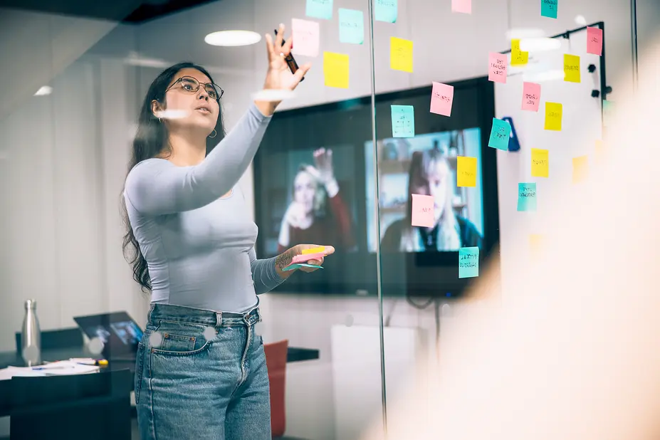 A woman is sticking Post-it notes during a meeting.