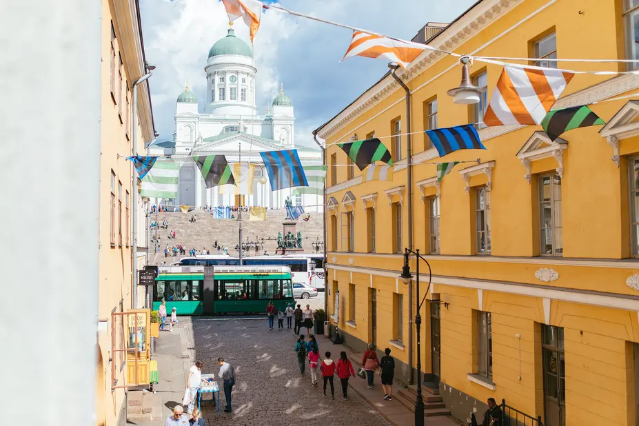 Viirejä kadun yllä, taustalla valkoinen Tuomiokirkko.