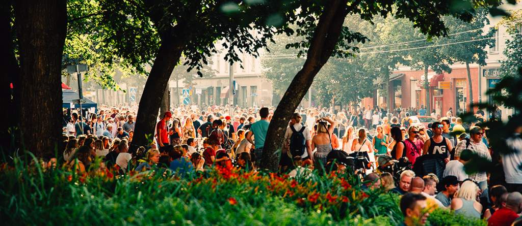 Kalio Block Partyssä kaupunkipuistossa paljon ihmisiä kesäpäivänä kuuntelemassa musiikkia puiden varjossa.