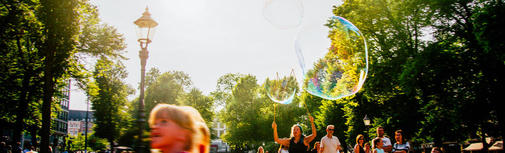 A child blows soap balloon in Esplanadi park in the centre of Helsinki.