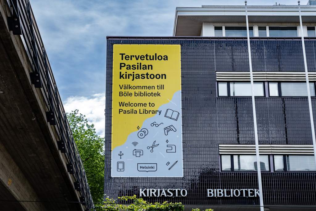 Pasilan kirjaston julkisivussa on Helsinki ilmeellä toteutettu  iso banderolli jossa tekstiä ja kuvitusikoneja 