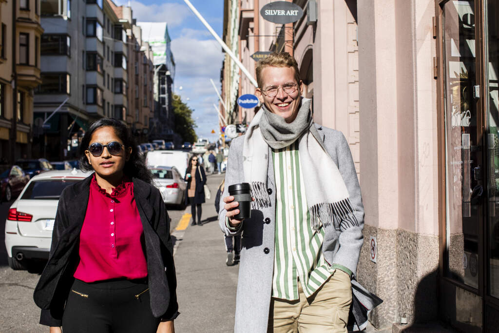 Nuori nainen ja mies kävelevät aurinkoisella kadulla Ullanlinnassa.