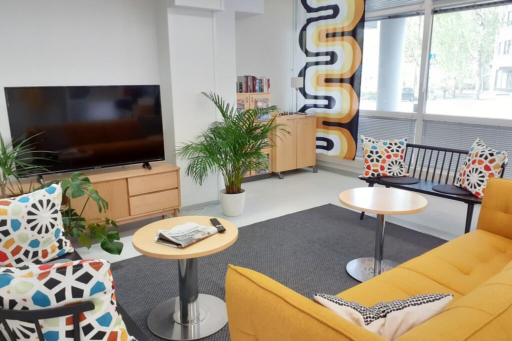 Keltainen sohva ja tv Stadin yhteisötalo Lassilan olohuoneessa