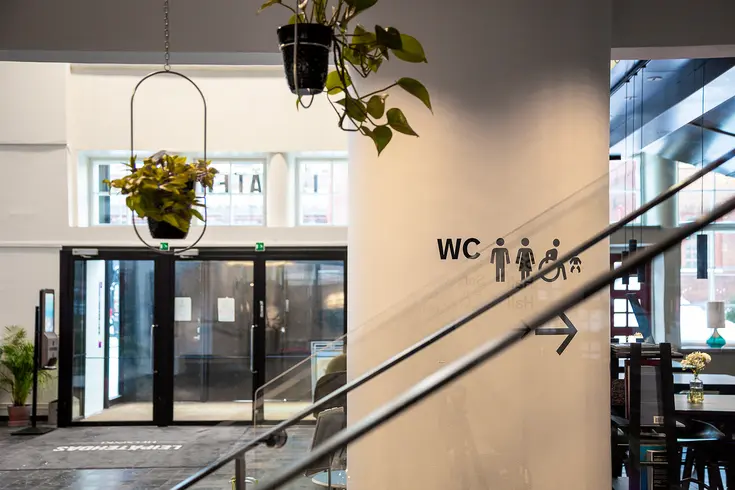Aulatila jossa opastekuvakkeita mustalla värillä valkoisella taustalla 