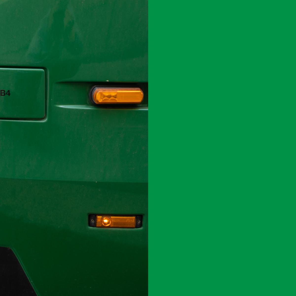 Lähikuva raitiovaunun vihreästä kyljestä ja vilkkuvalosta 