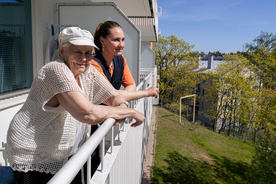 Kuvassa kotihoidon asiakas ja sosiaaliohjaaja asiakkaan kotona parvekkeella.