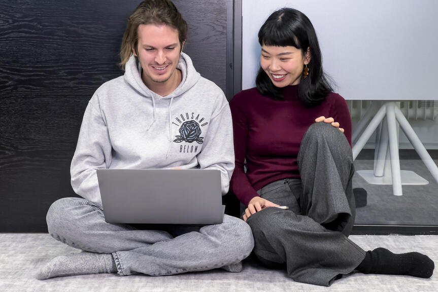 Kaksi henkilöä katsoo läppäriä.