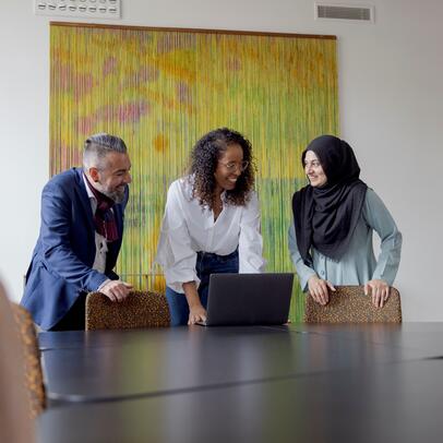 Kolme henkilöä työskentelee yhdessä.