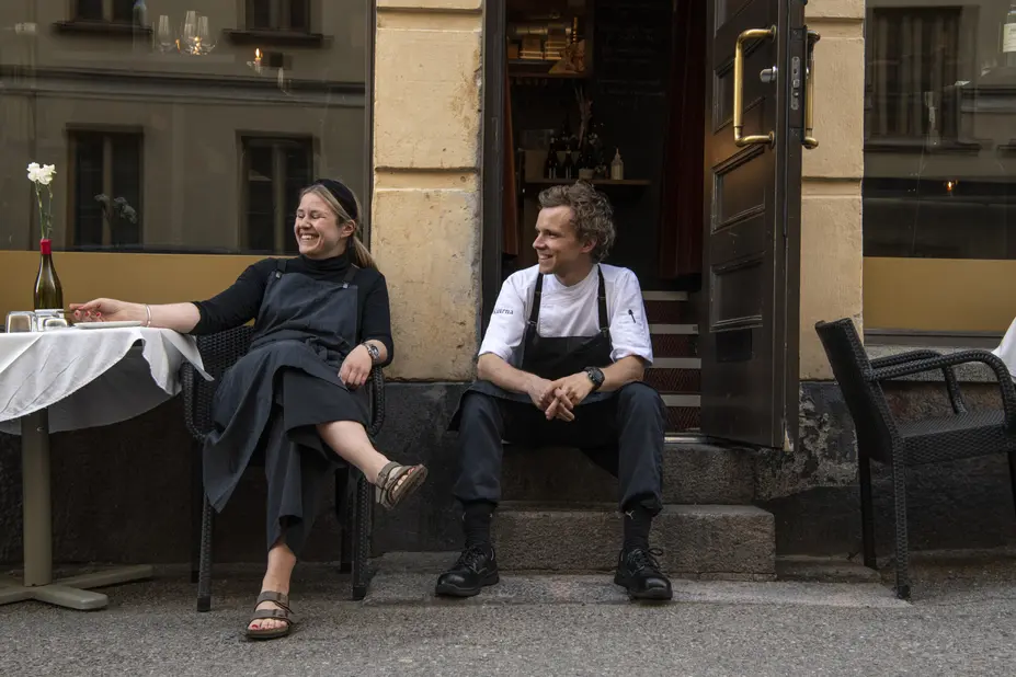 Two people sitting outside a restaurant.